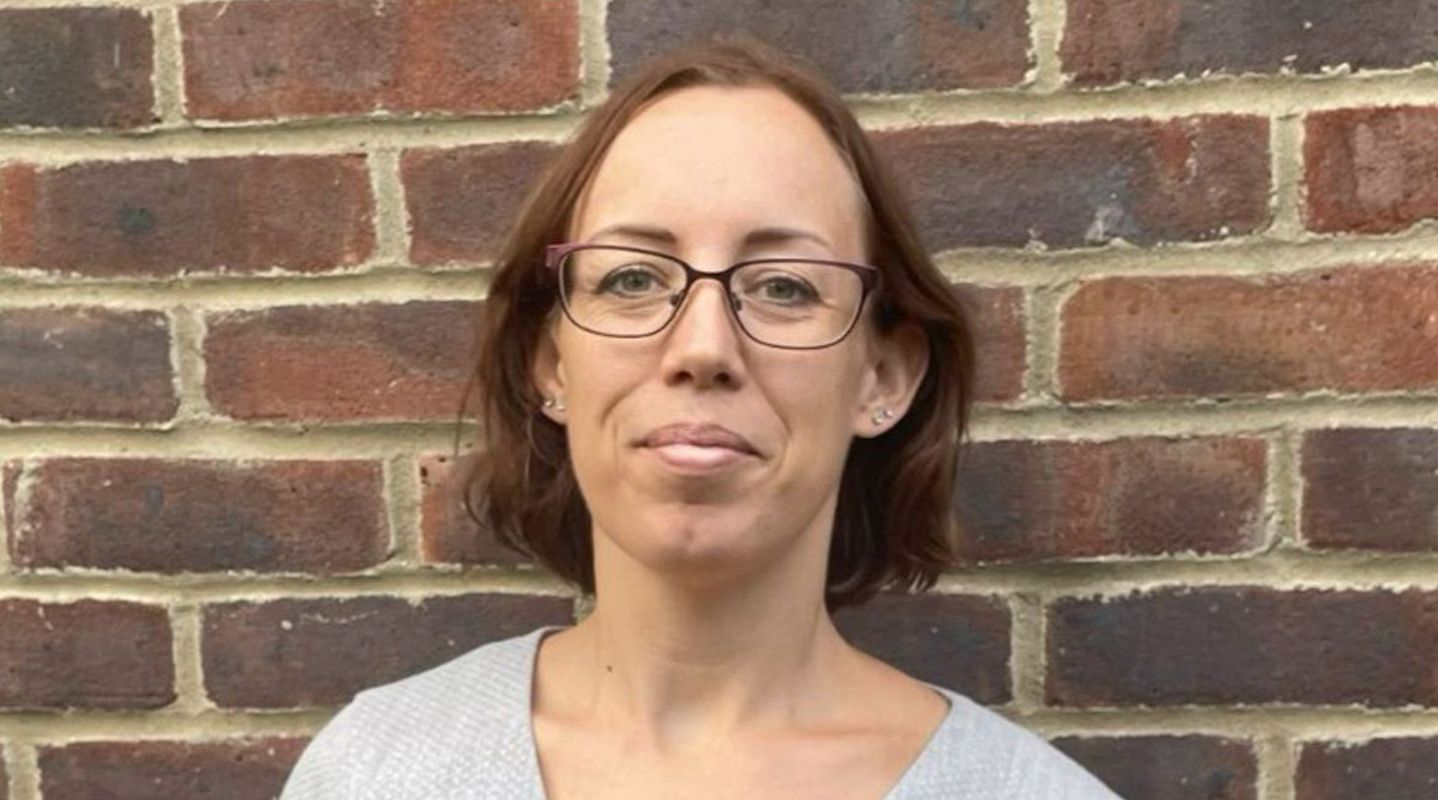 Person standing in front of brick wall